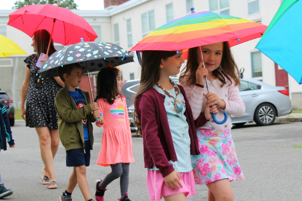 students sharing umbrellas