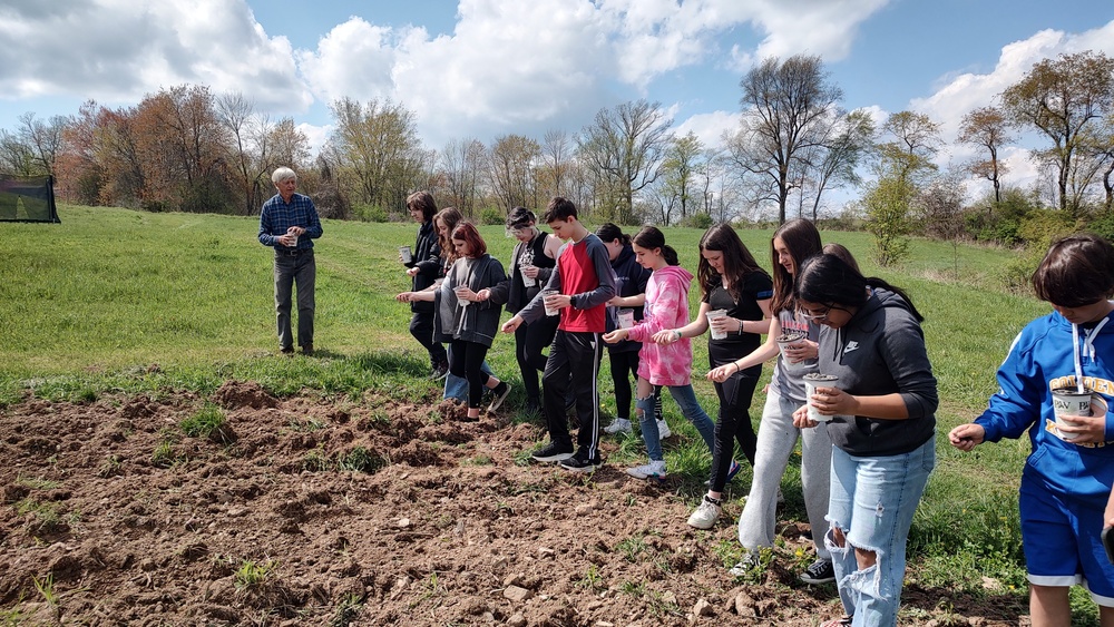 Service Club planting seeds in field