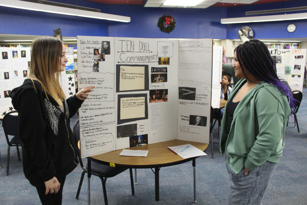 two girls look at posterboard display