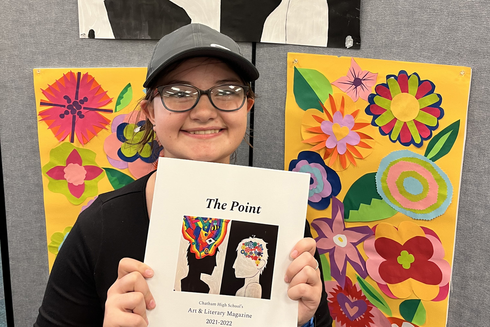 Girl holding up The Point magazine
