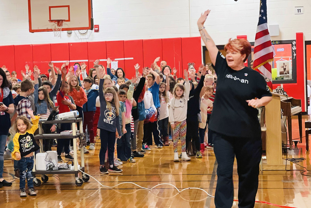 Darci Orway waves to students
