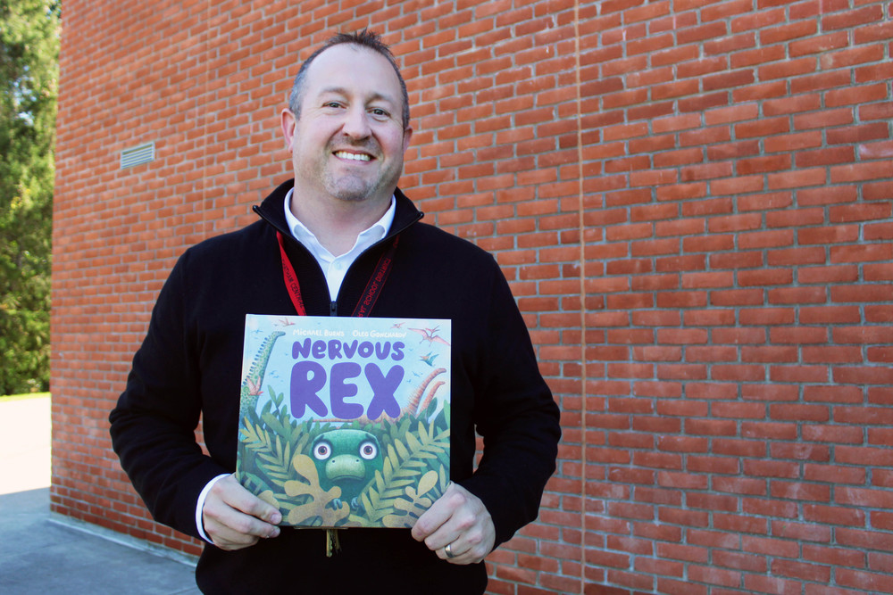 Mike Burns holding copy of his book Nervous Rex