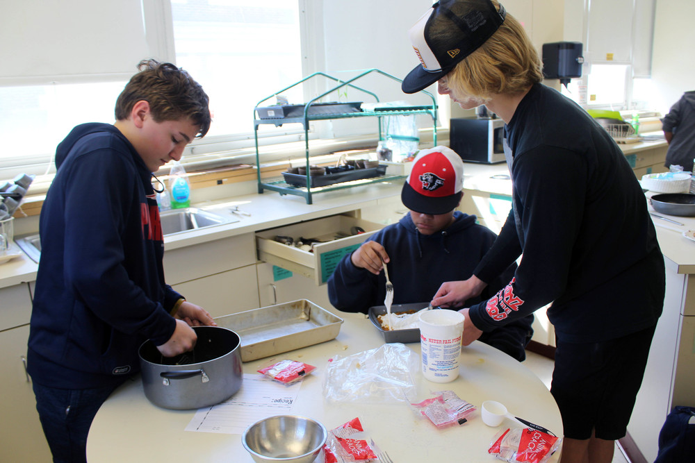 three boys making candied sweet potatoes