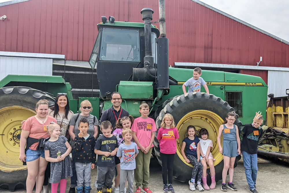 classes pose with big farm tractor