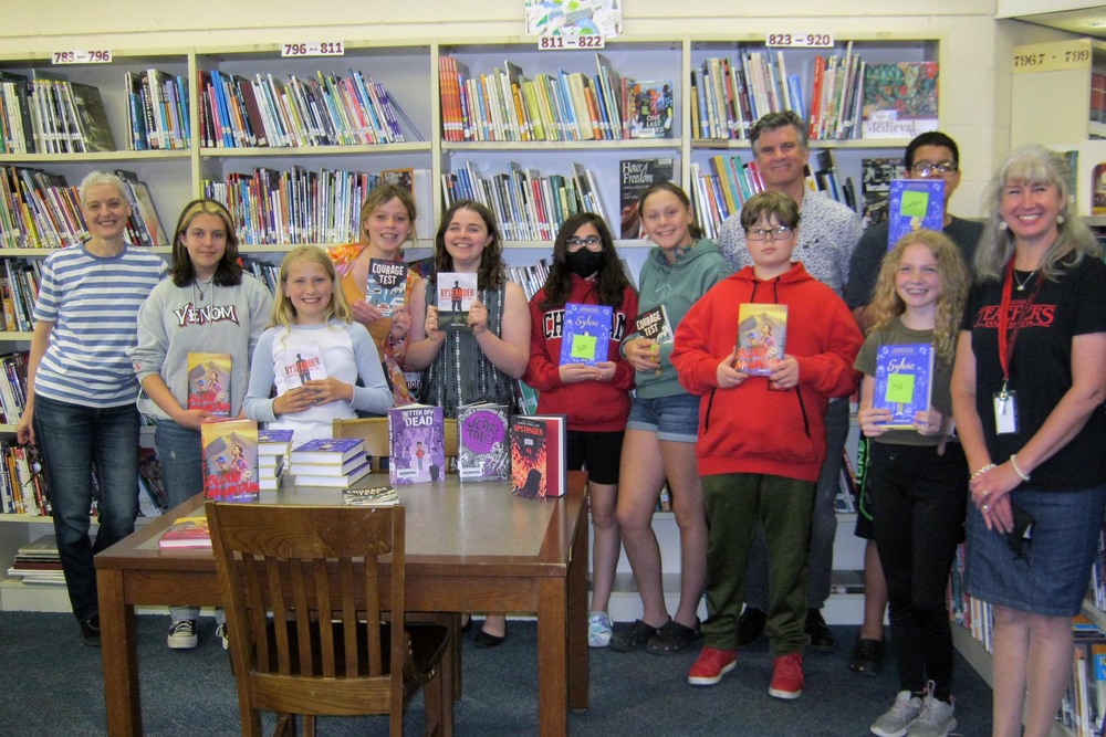 authors and students pose for photo in library