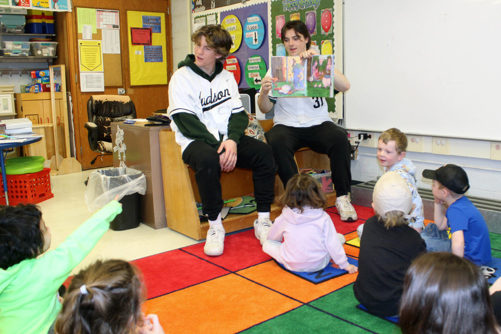 two baseball players reading to pre0k classrrom