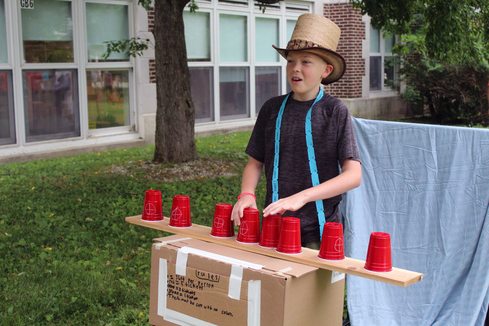 boy wearing top hat playing cup game