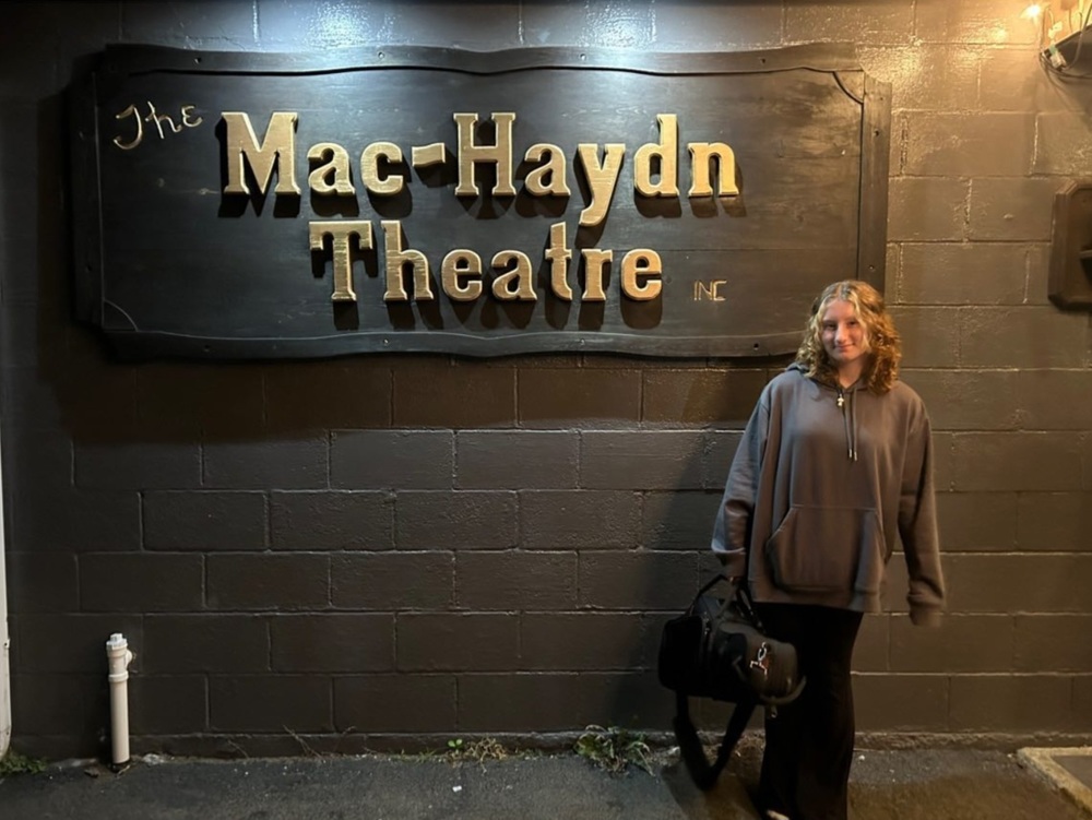 Teenage Girl sanding in front of Mac-Haydn Theatre sign