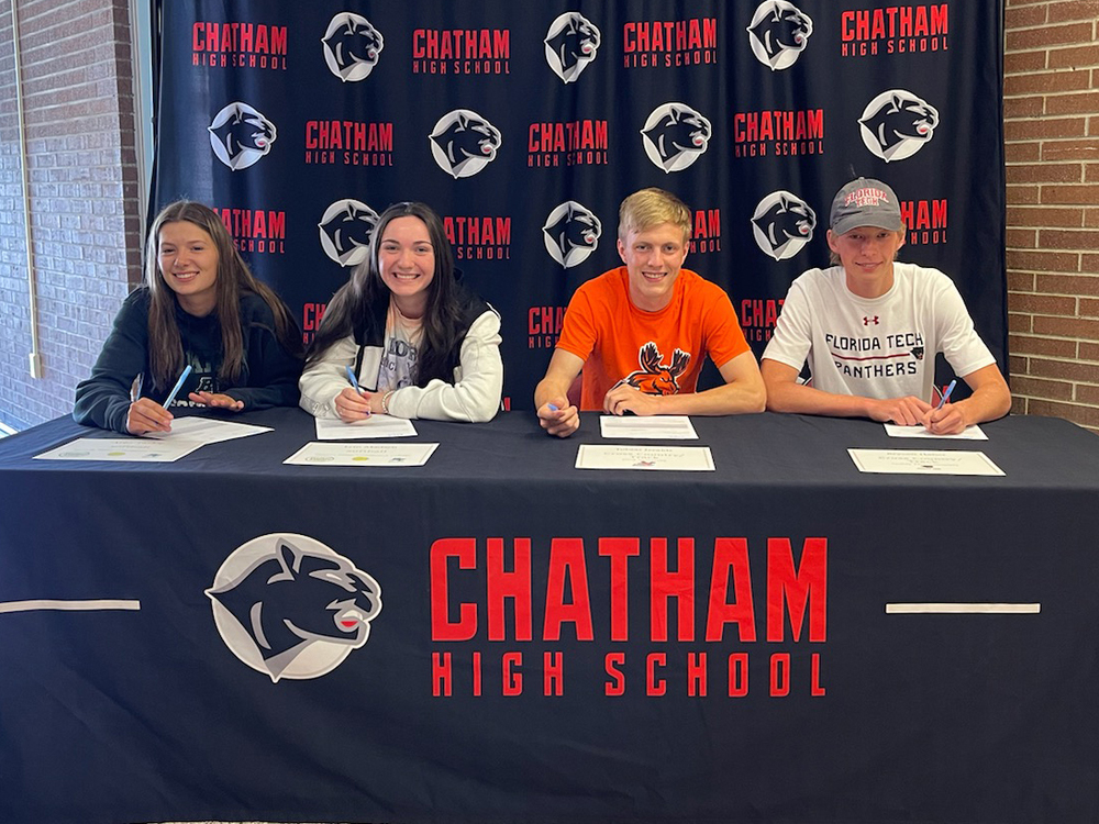 two girls and two boys sitting at table with Chatham panther logo on it