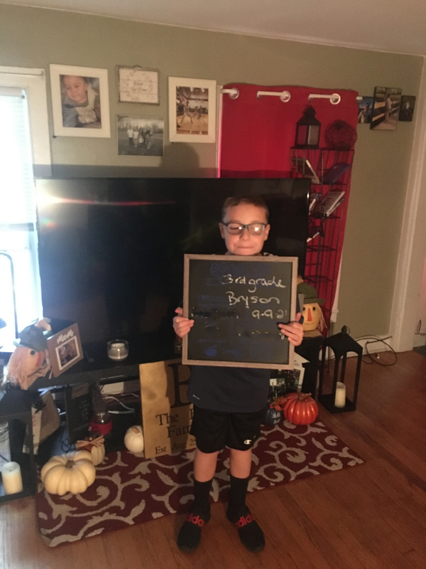 boy holding first day sign