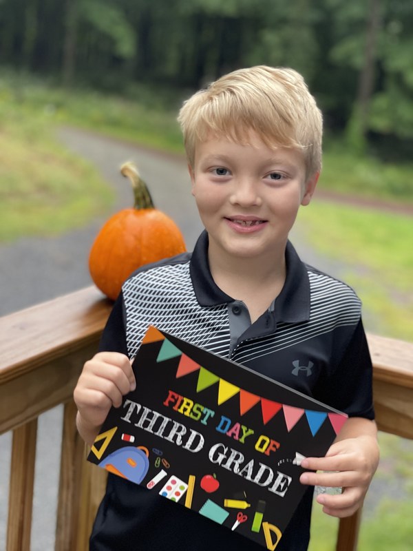 boy holding first day of school sign