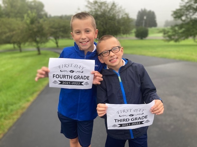 two boys holding first day signs