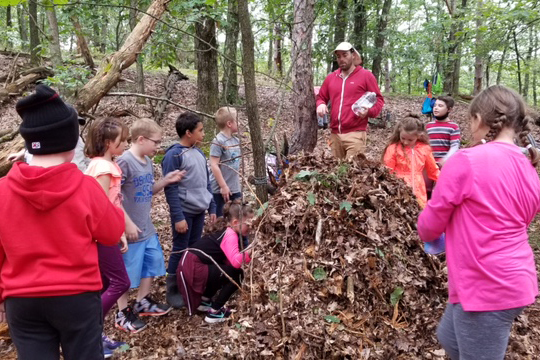 students building stick and leaf shelter