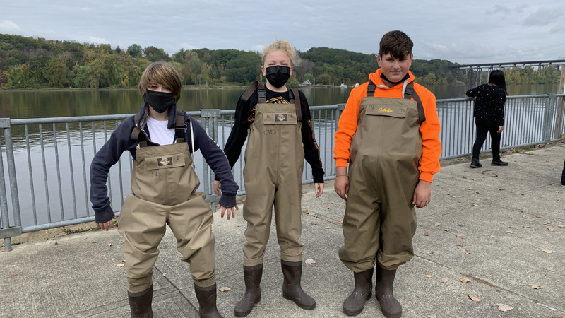 Three students wearing waders