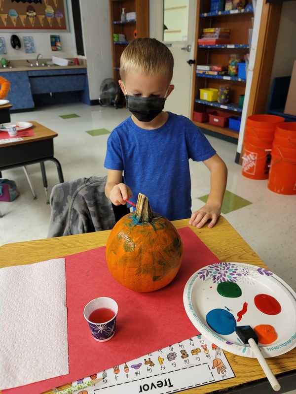 boy painting pumpkin