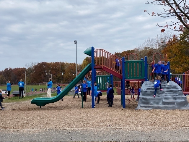 kids in blue shirts on playground equipment 
