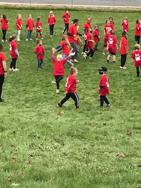 kids in red shirts dancing on grass
