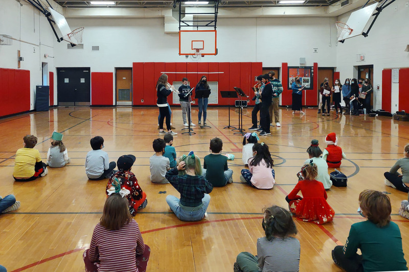 students playing music in front of elementary school audience