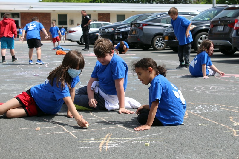 students drawing with chalk on sidewalk