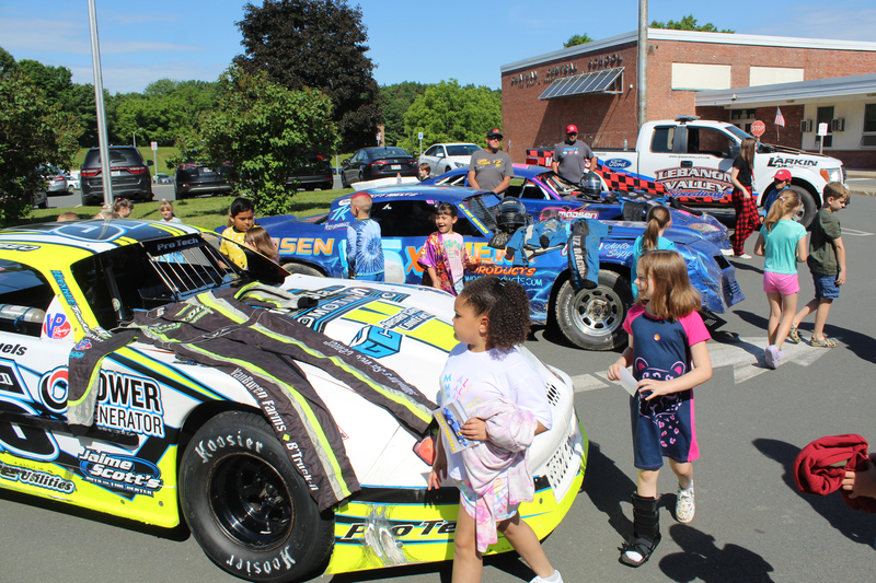 students look at race cars