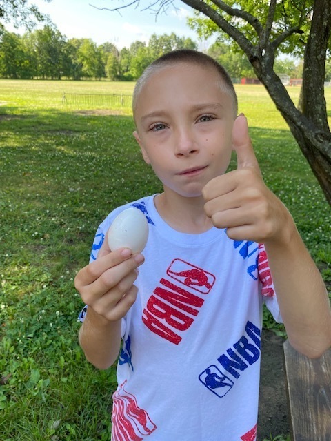 boy holding egg giving thumbs up