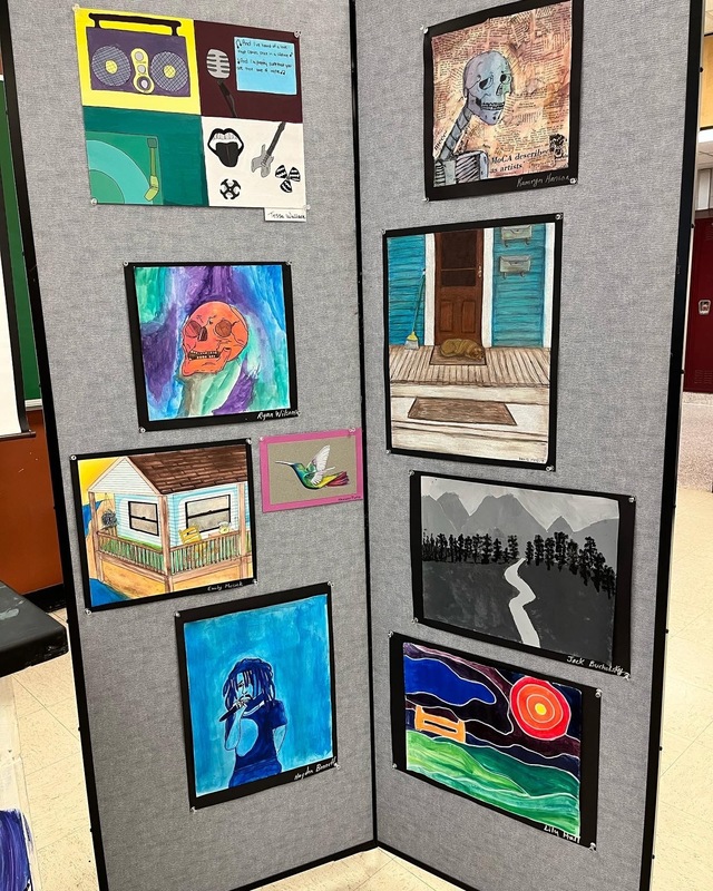 Student art display showing multiple paintings