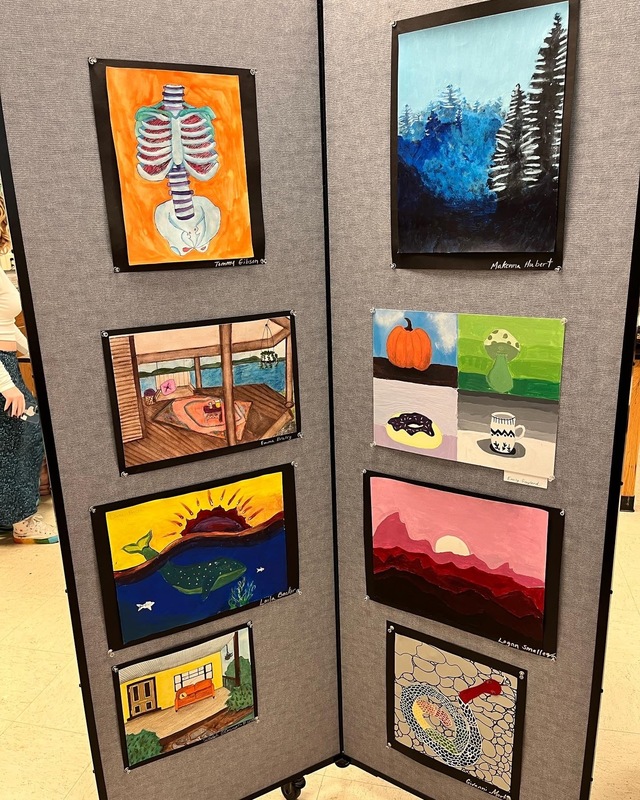 Student art display showing multiple paintings