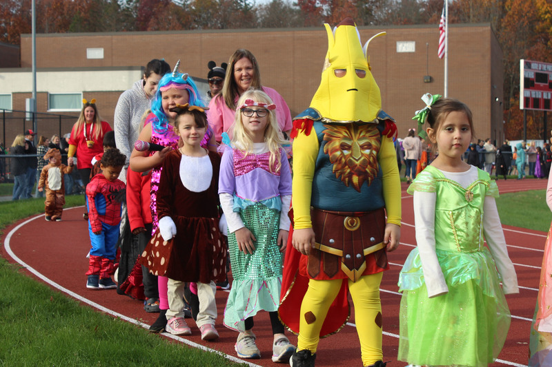 students in costume walking on track