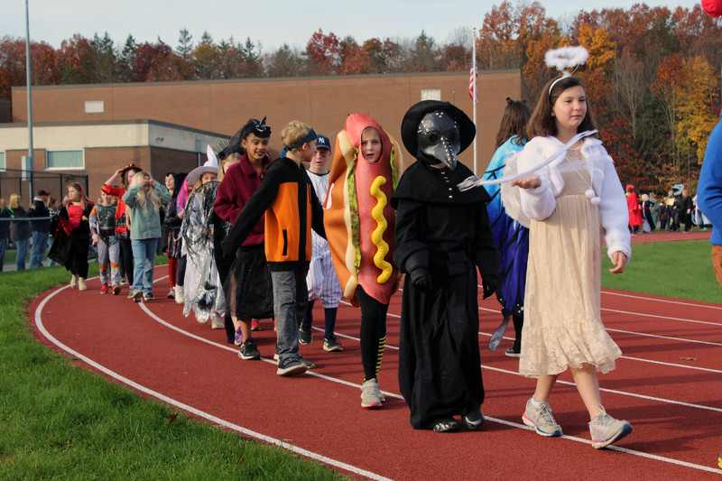 students in costume walking on track