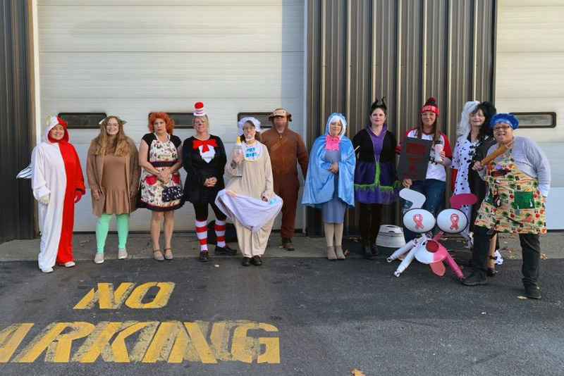 transportation staff dressed in costumes in front of bus garage