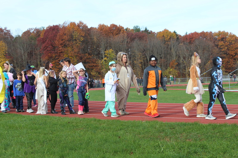 students in costumes marching on track 