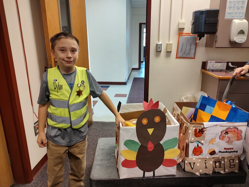 boy standing with boxes decorated in Thanksgiving themes