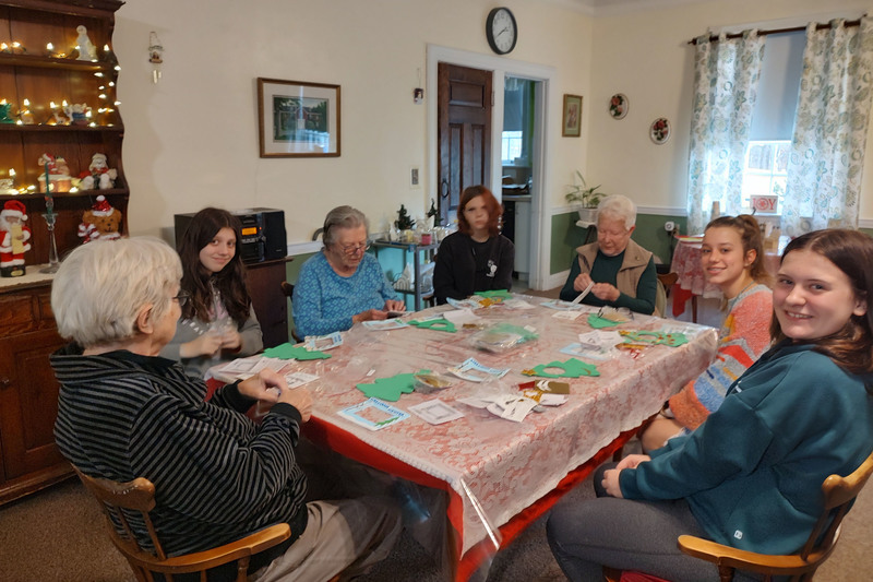 students and seniors playing bingo at table