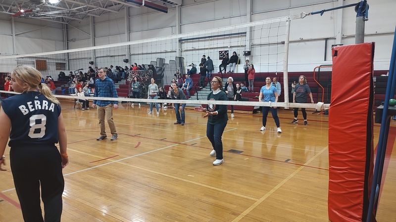 Students playing volleyball against staff
