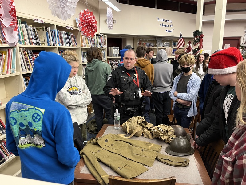 Deputy describing WWI items on table to students 