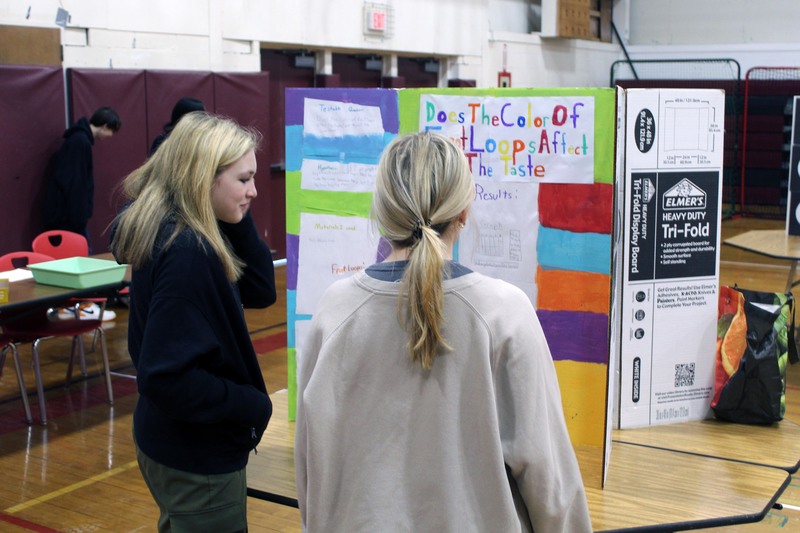two girls looking at science fair project