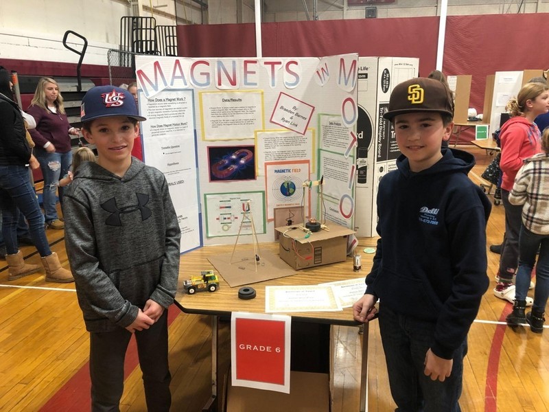 two boys pose with magnets science project