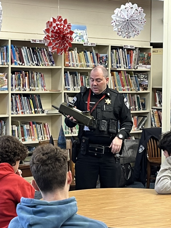 Police officer showing students World War Two walkie-talkie