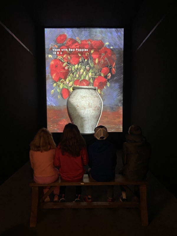 students look at Van Gogh painting of flowers in vase