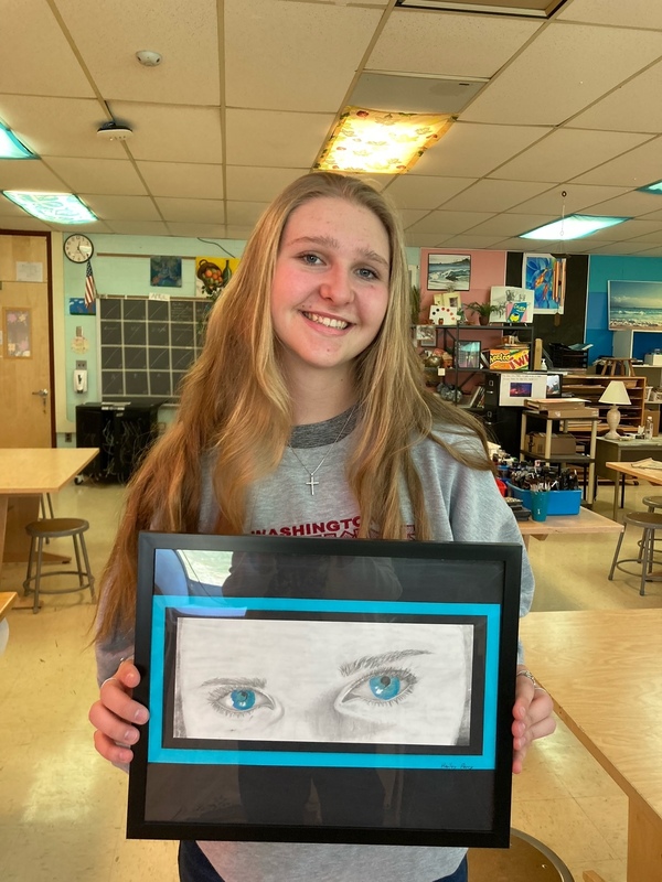 girl holding drawing of eyes