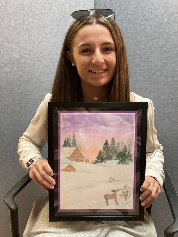 Girl holding painting of winter landscape