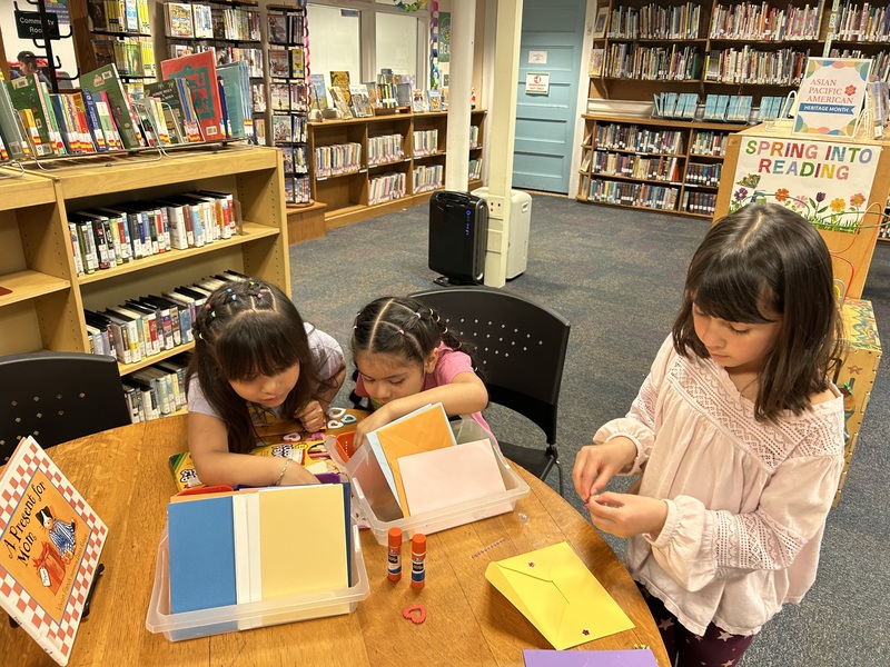 three girls playing in library