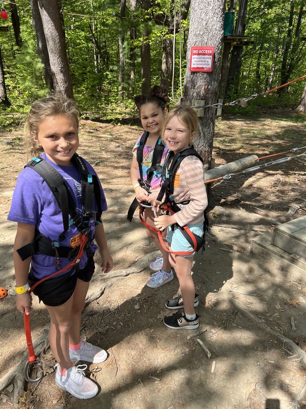 three girls wearing harnesses