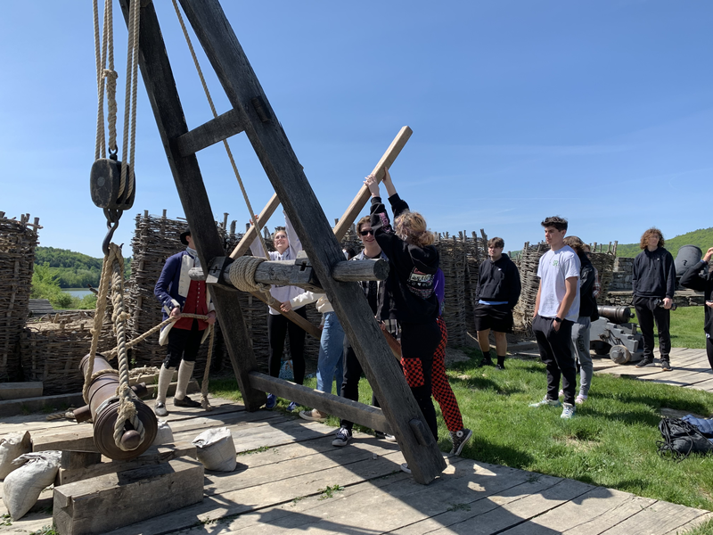 students using pulley to hoist cannon