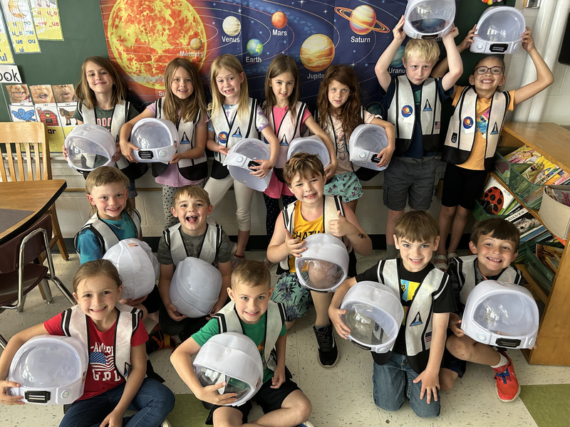 Class poses with space helmets