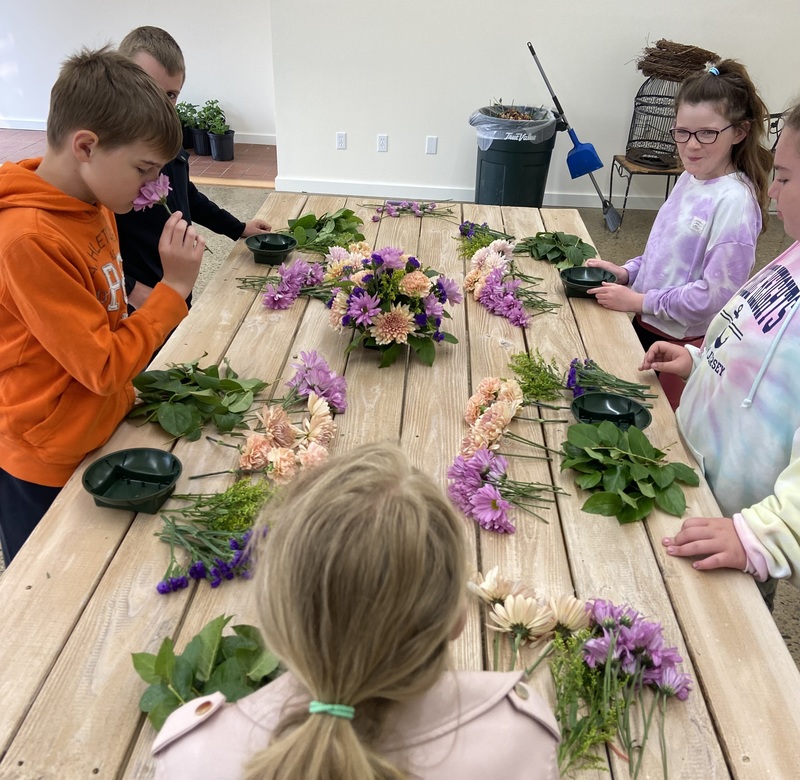 students making floral arrangements on table