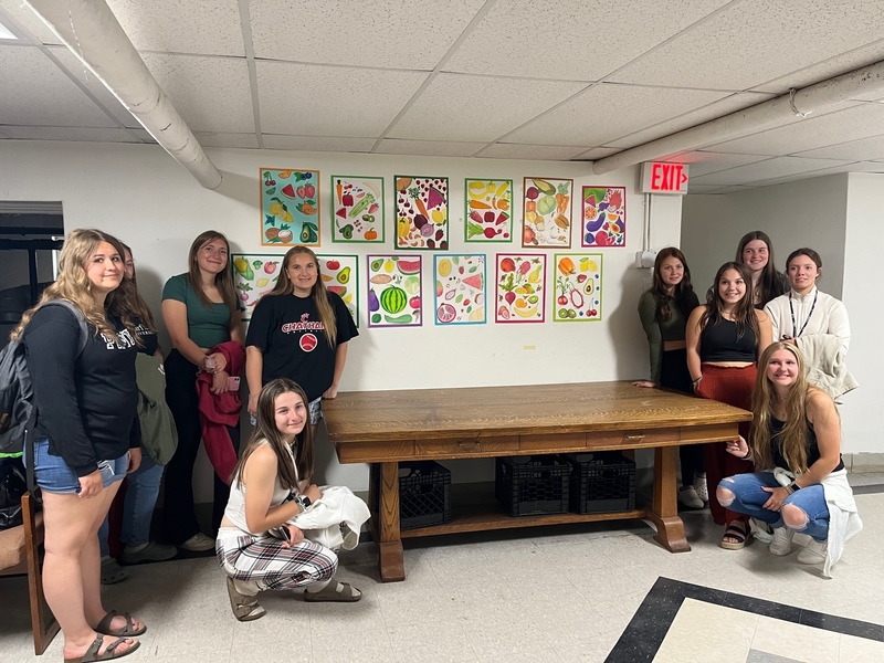 students pose with art on walls