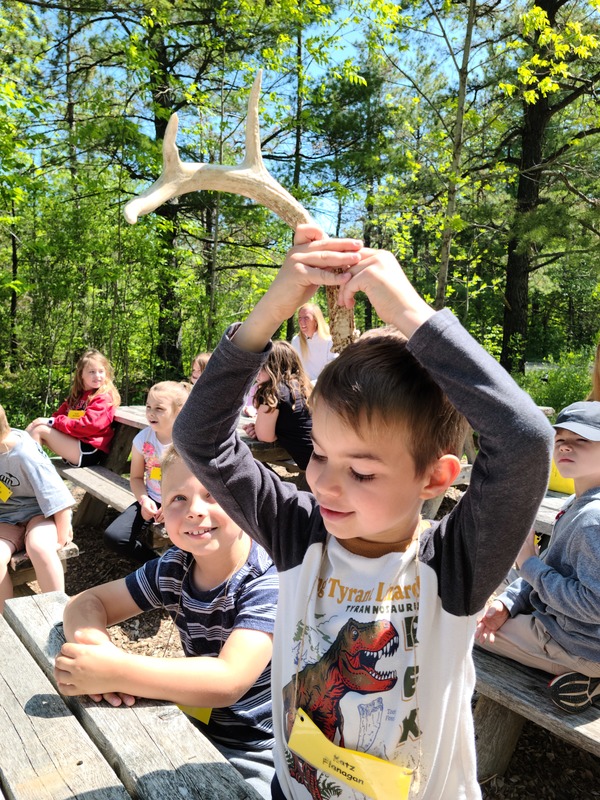 student holding antler over head