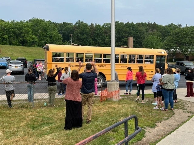 students waving to students on bus