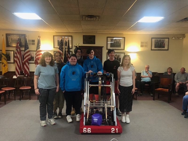 team poses with robot in Elks Lodge